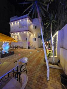 a patio with chairs and a building at night at El Mandara Residence Inn in Alexandria