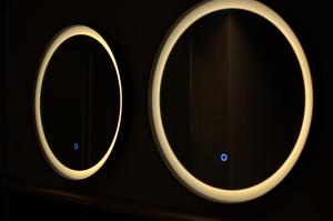 a pair of round mirrors on a black background at Dolomiten Apartments in Tesero