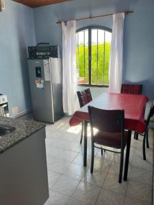 a kitchen with a table and chairs and a refrigerator at Rincón Bosc in Ramallo