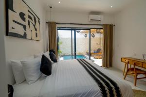 a bedroom with a bed and a desk and a window at Virgo Sun House in Uluwatu +46 photos