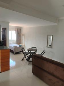 a room with a bed and a table and chairs at Aconchego da Alegria!!! in Porto Seguro