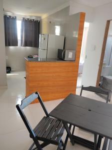 a table and a chair in a room with a kitchen at Aconchego da Alegria!!! in Porto Seguro