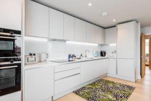 a kitchen with white cabinets and a rug at Harbours Edge - Front-Line Harbour Views in Poole