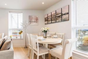 a white dining room with a white table and chairs at Harbours Edge - Front-Line Harbour Views in Poole