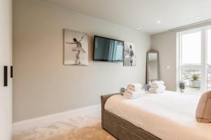 a bedroom with a bed and a tv on a wall at Harbours Edge - Front-Line Harbour Views in Poole