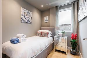 a small bedroom with a bed and a window at Harbours Edge - Front-Line Harbour Views in Poole +30 photos