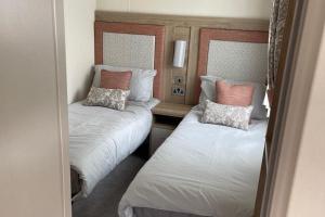 two beds in a small room with two pillows at The Royal Oak - Sleeps 4 - Deck - Free Parking in Holsworthy