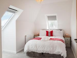 a bedroom with white walls and a bed with red accents at Palace View - Uk40569 in Falkland