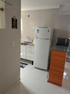 a kitchen with a white refrigerator and a counter at Aconchego da Alegria!!! in Porto Seguro +11 photos