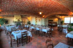 restauracja ze stołami i krzesłami oraz ceglaną ścianą w obiekcie Azienda Agrituristica Alcastlè w mieście Montabone