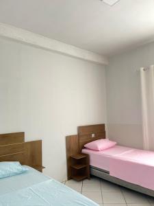 two beds in a room with pink sheets at Vista da Serra, Casa Térrea e Superior, entradas independentes in Cavalcante