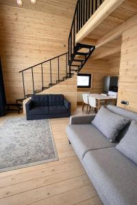 a living room with a couch and a staircase at Gudauri Deka Alpine Cottages in Gudauri +18 photos