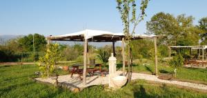 a picnic shelter with a picnic table in a garden at L' Alcova Del Conte in Dragoni