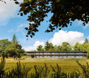 an office building with a field in the foreground at Massembre in Heer