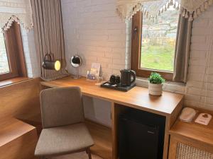 a desk with a chair next to a window at The Stone Sky Hotel in Gjirokastër