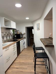 a kitchen with a counter and stools in it at Charmant appartement Chaleureux in Hyères