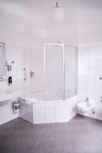 a white bathroom with a shower and a toilet at Hotel Villa Kisseleff in Bad Homburg vor der Höhe +31 photos