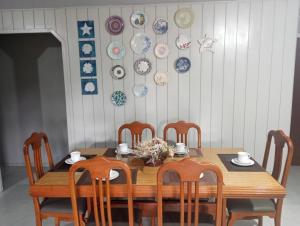 a dining room table with chairs and plates on the wall at Casa de verão vó judite -praia Sulmar- 4 quartos in Balneário Gaivotas