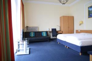 a hotel room with two beds and a desk at Hotel Villa Kisseleff in Bad Homburg vor der Höhe