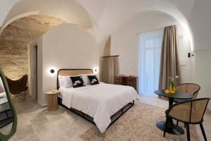 a bedroom with a bed and a table and chairs at CAVA Urban Relais & Pool in Lecce