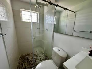a bathroom with a shower and a toilet and a sink at Hotel Casa La Macana in Macanal