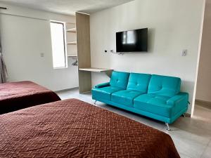 a blue couch in a room with a flat screen tv at Hotel Casa La Macana in Macanal