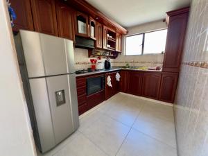 a kitchen with wooden cabinets and a white refrigerator at Hotel Casa La Macana in Macanal +7 photos