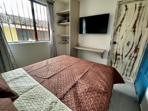 a bedroom with a bed and a tv and a window at Hotel Casa La Macana in Macanal
