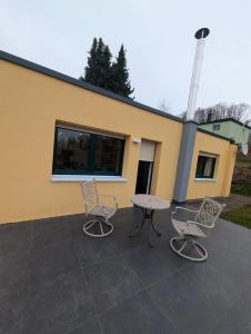 a patio with a table and chairs in front of a building at Sonnenschein & Ruhe in Losheim