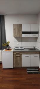 a kitchen with white cabinets and a stove top oven at Apartmani METRO in Loznica