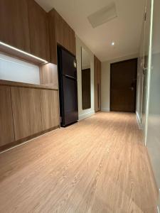 a large empty room with wooden floors and doors at Novotel at Acqua, The Hotel Residences by RM in Manila