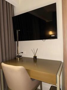 a desk with a chair and a television on a wall at Novotel at Acqua, The Hotel Residences by RM in Manila