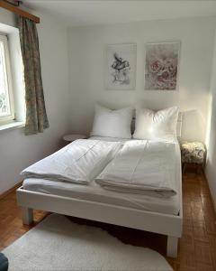 a bed with white sheets and pillows in a bedroom at Ferienwohnung Wasserfall in Golling an der Salzach