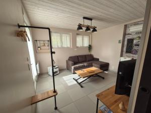a living room with a couch and a table at Charmant appartement indépendant Ty-Oustal in Millau