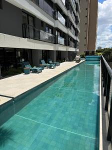 a swimming pool in front of a building at Luxo e Aconchego 1Qt Com Sacada GY03 proximo Vaca Brava in Goiânia