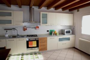 a kitchen with white cabinets and a stove top oven at A casa di Giò in Vittorio Veneto