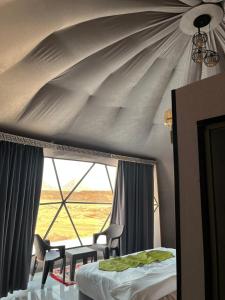 a bedroom with a ceiling with a window and chairs at SELEN RUM LUXURY CAMP & Jeep Tours in Wadi Rum