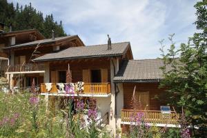 a log house with a balcony and flowers at Chalet Ski in&out in Les Collons