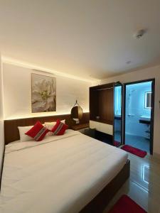 a bedroom with a large white bed with red pillows at Phao Hotel in Vung Tau