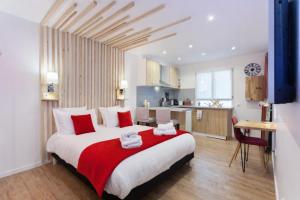 a bedroom with a large bed and a kitchen at Les studios de la faisanderie in Chantilly