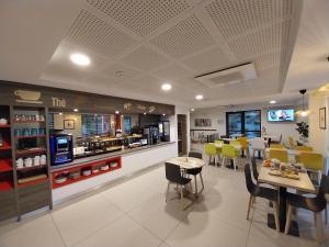 a restaurant with a counter and tables and chairs at Hotel Arena Toulouse in Toulouse