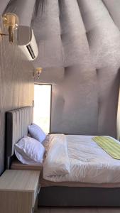 a bedroom with a bed and a window at SELEN RUM LUXURY CAMP & Jeep Tours in Wadi Rum
