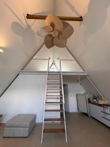 a ceiling fan and a ladder in a attic at Selah Cabaña de dos habitaciones in Villa Las Rosas