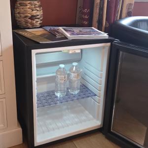 two bottles of water in an empty refrigerator at Green Hill Guest Room Overijse in Overijse