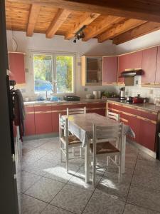 a kitchen with red cabinets and a table and chairs at Chez Lily in Domme +13 photos