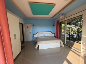 a bedroom with a bed with a blue wall at Mist Leaf Villa Mahabaleshwar in Mahabaleshwar