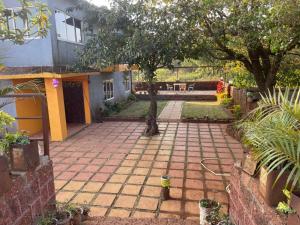 a patio with a tree in the middle of a yard at Mist Leaf Villa Mahabaleshwar in Mahabaleshwar