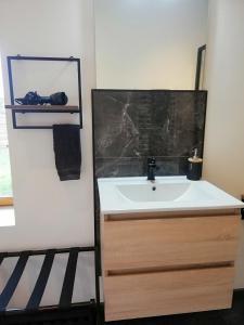a bathroom with a sink and a black counter at Le Box Circuit Magny-Cours in Saint-Parize-le-Châtel