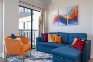 a living room with a blue couch and an orange chair at Lakeview 2 suites 6 min to New EPIC Universe in Orlando