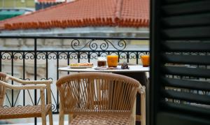 a table with two chairs and food on a balcony at Klitiou 7 Boutique Hotel in Athens